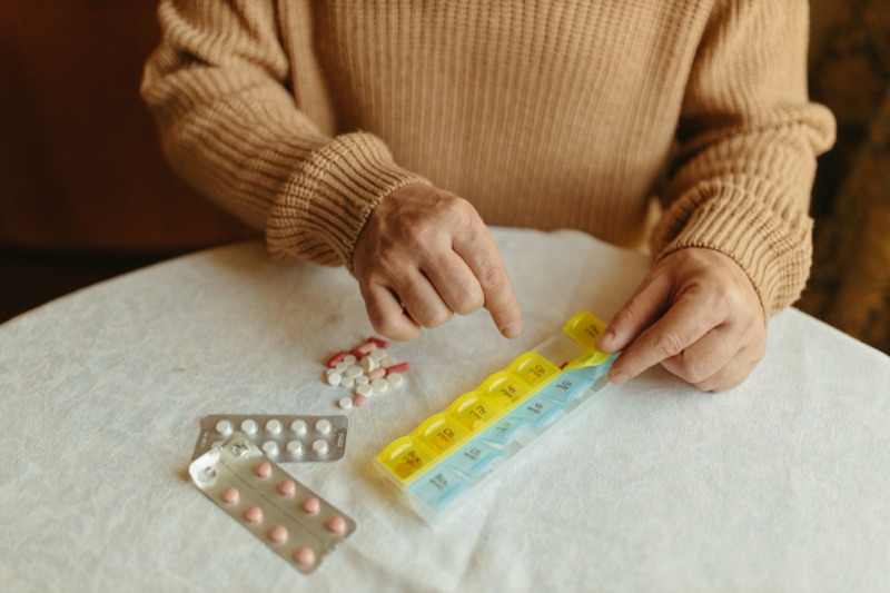 お薬カレンダーに薬を仕分ける手元。薬局と連携した処方・服薬管理
